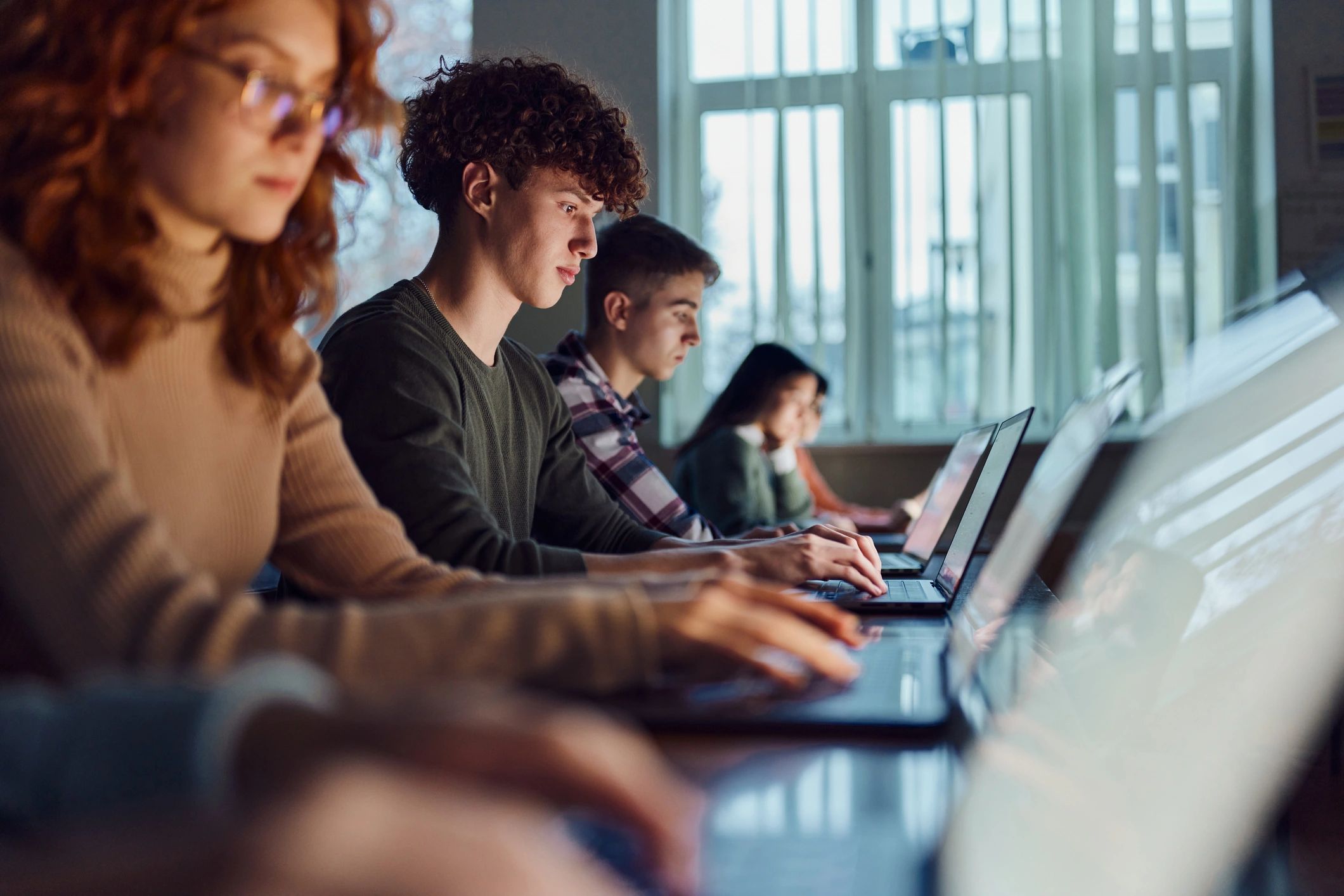 People working on laptops in a classroom-style setting